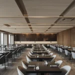 A modern restaurant or open office with acoustic panels or baffles installed elegantly. Focus on noise contro
